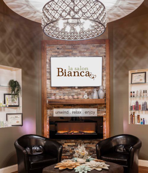 La Salon Bianca waiting area with fireplace and chandelier