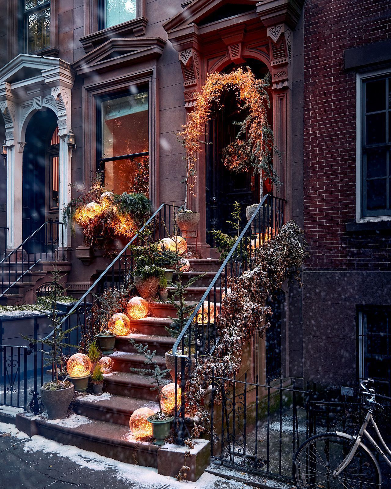 Festive brownstone entrance decorated with glowing globe lights, greenery, and winter wreath — elegant Philadelphia holiday wedding inspiration
