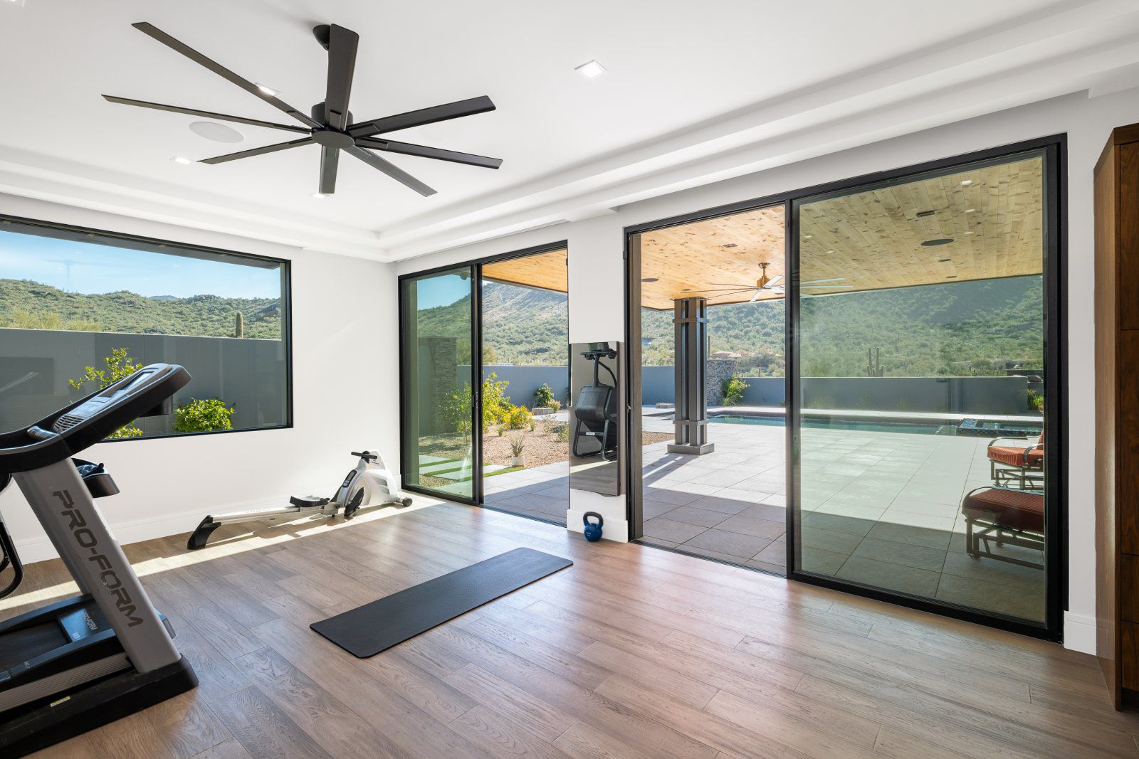 Awake Windows and Doors Series 275 sliding glass patio doors with black frames open home gym to covered patio and lap pool 