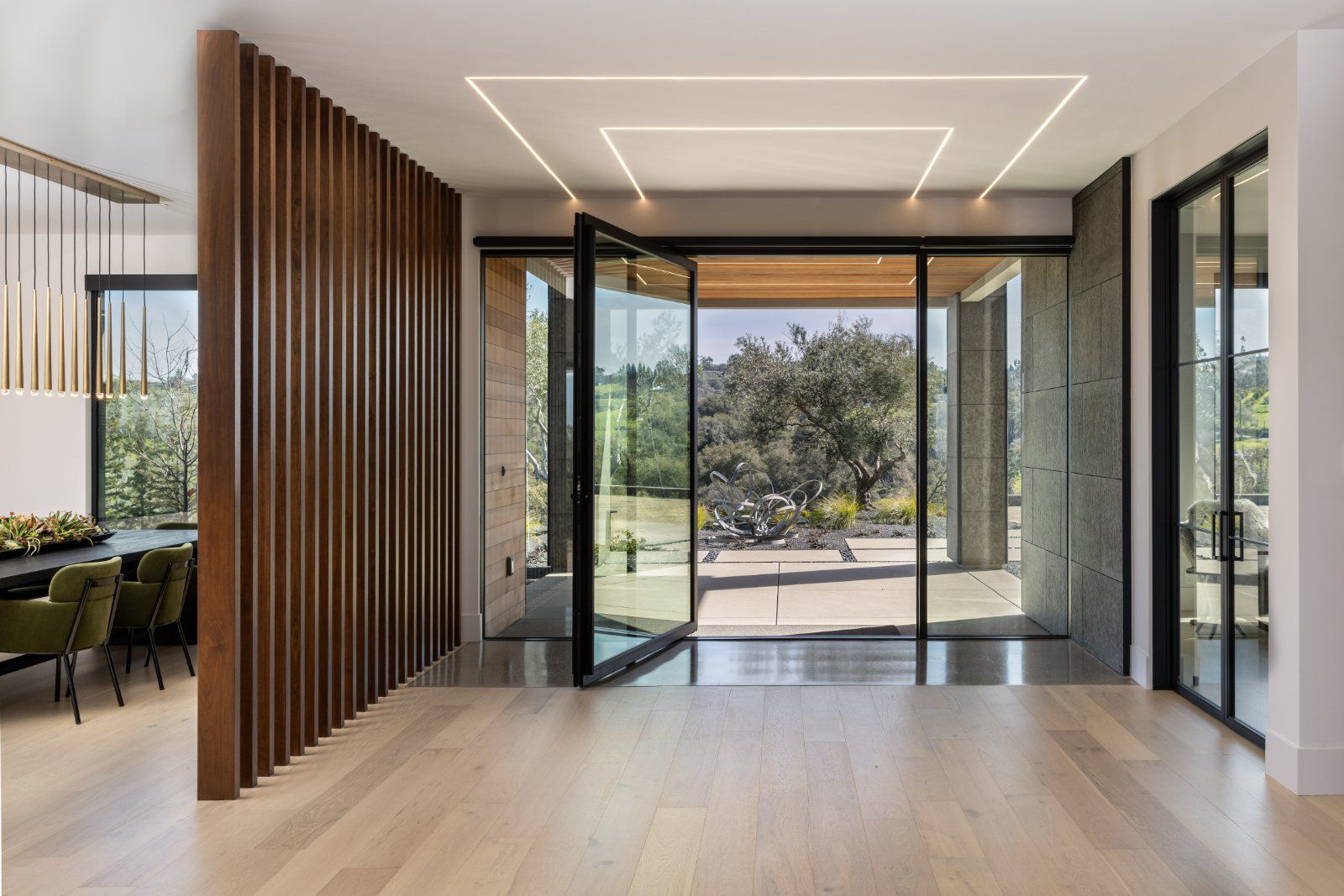 Pivot door with sidelights from Awake Windows & Doors 555 Series creates in a modern entryway