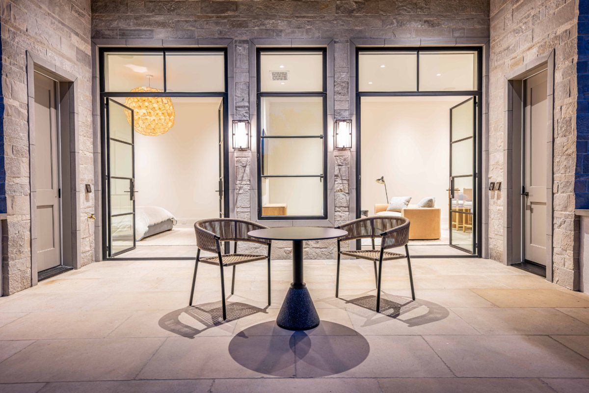 Two sets of Euroline steel hinged French doors create dramatic entryways to an outdoor terrace.