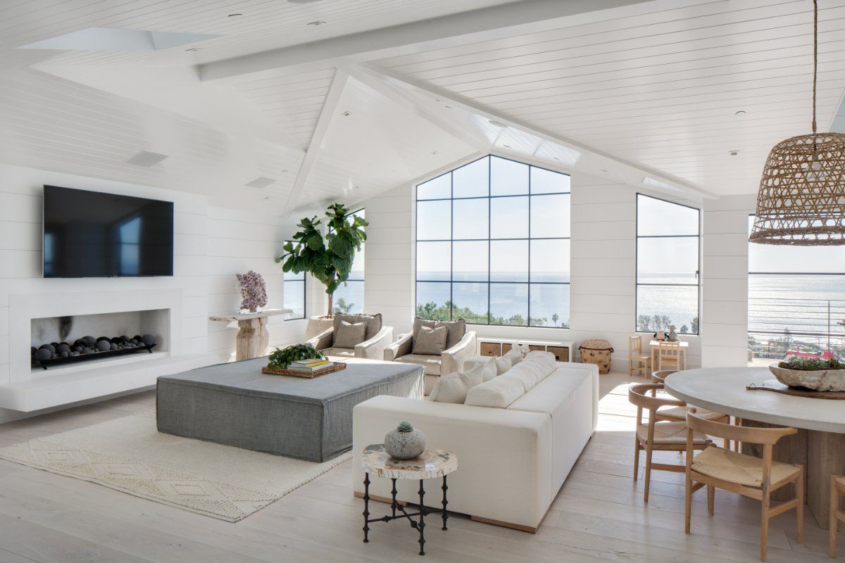 Euroline steel windows create a wall of windows that fills the room with natural light and highlights the tall ceilings and views.