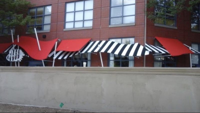 A retractable awning installed on the patio of a modern home. This outdoor shade canopy can be extended and retracted to control sunlight exposure, perfect for residential use. The sleek design complements the home’s exterior, offering flexibility fo