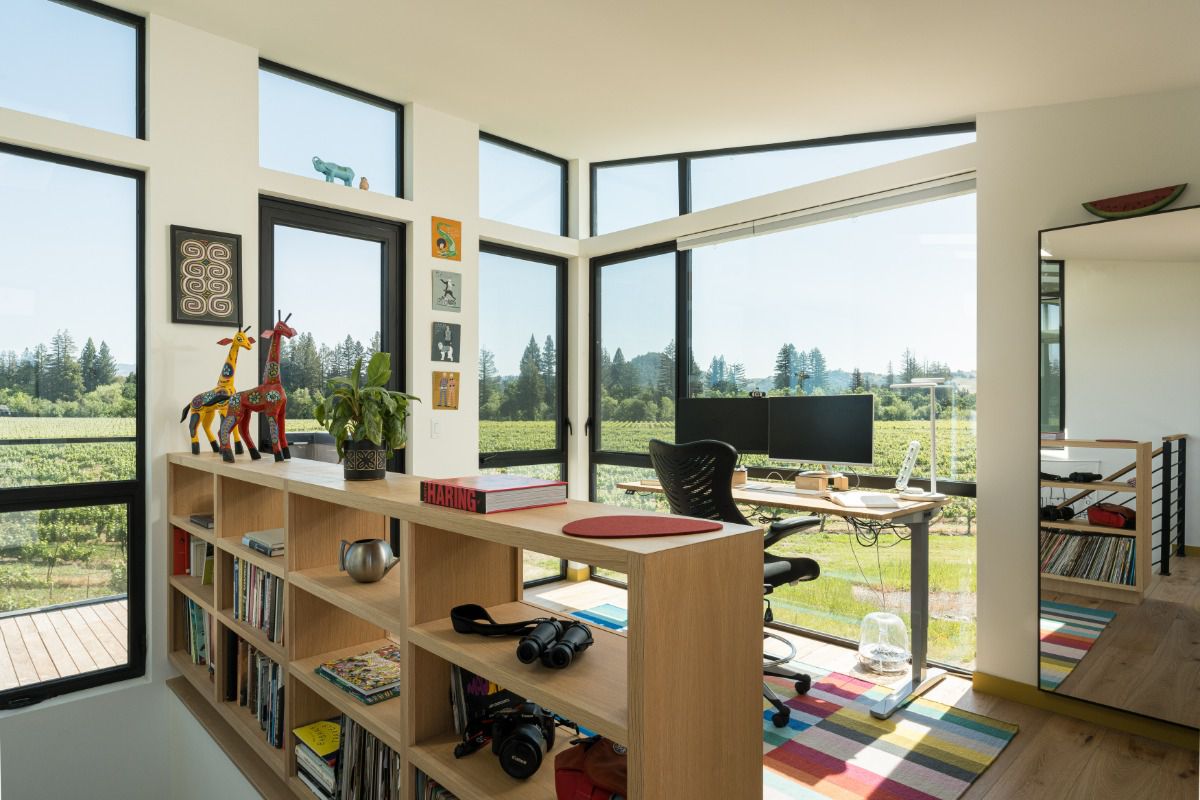 All Weather Series 6000 aluminum windows with slim black frames provide expansive vineyard views from a modern home office.