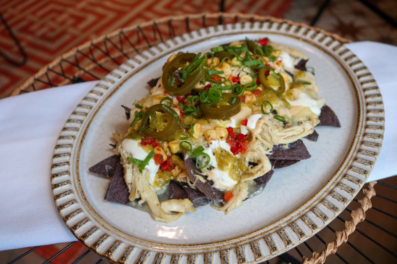 BLUE CORN NACHOS - green chili chicken, queso, corn salad, jalapeños, salsa verde, lime crema