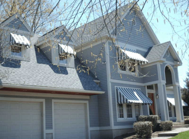Striped blue awnings offer classic charm and effective shading for this residential window setup. Mineola Signs installs custom residential awnings that improve energy efficiency and elevate curb appeal.