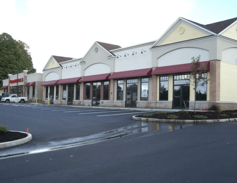 These uniform burgundy awnings give this shopping plaza a cohesive and professional appearance. Mineola Signs provides custom storefront awnings that support branding and customer recognition. Perfect for retail centers across NY, NJ, and CT, our awn
