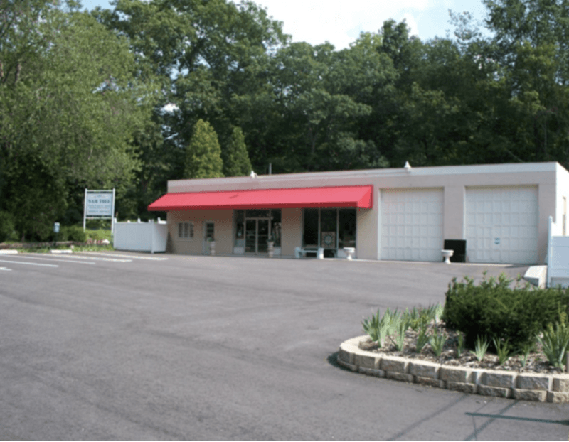 A sleek flat red awning offers shade and branding for this commercial entrance. Installed by Mineola Signs, it’s part of our range of low-profile awnings perfect for offices, restaurants, and shops. Our designs offer clean lines and solid protection,
