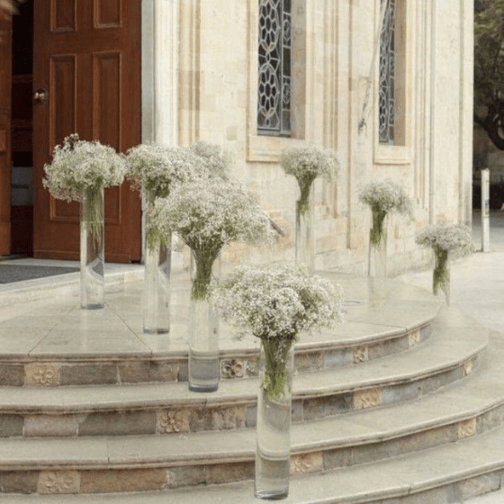 Romantic wedding ceremony entrance of a church in Philadelphia with baby's breath in tall glass vases on stone steps