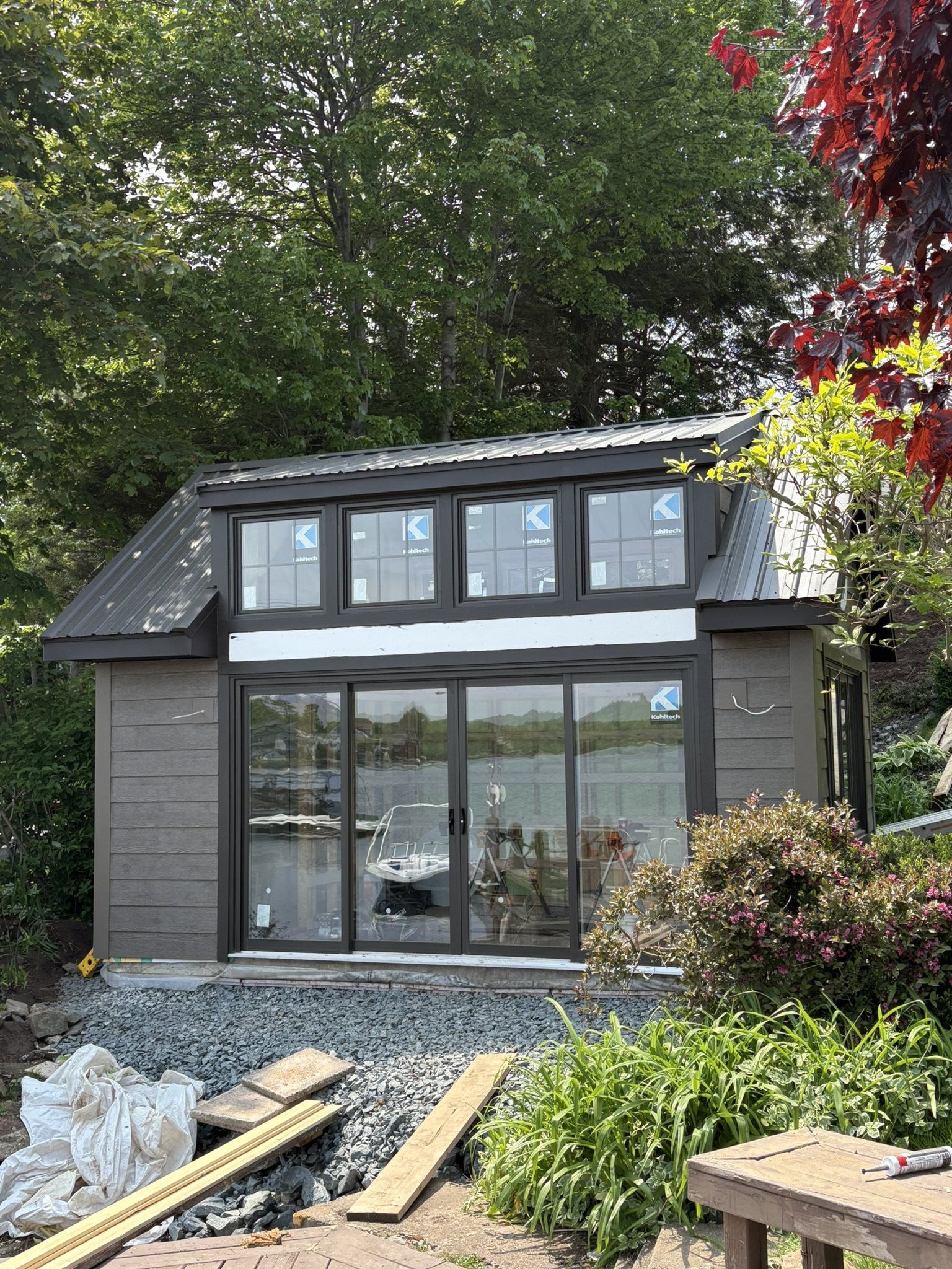 Small boathouse with brown siding and brown metal roof