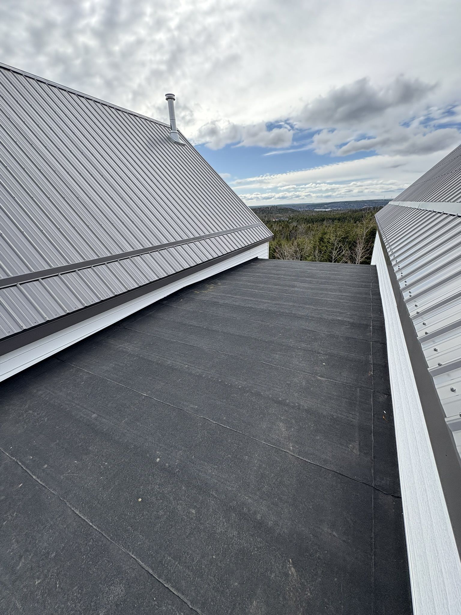 Large white farmhouse with grey metal roof