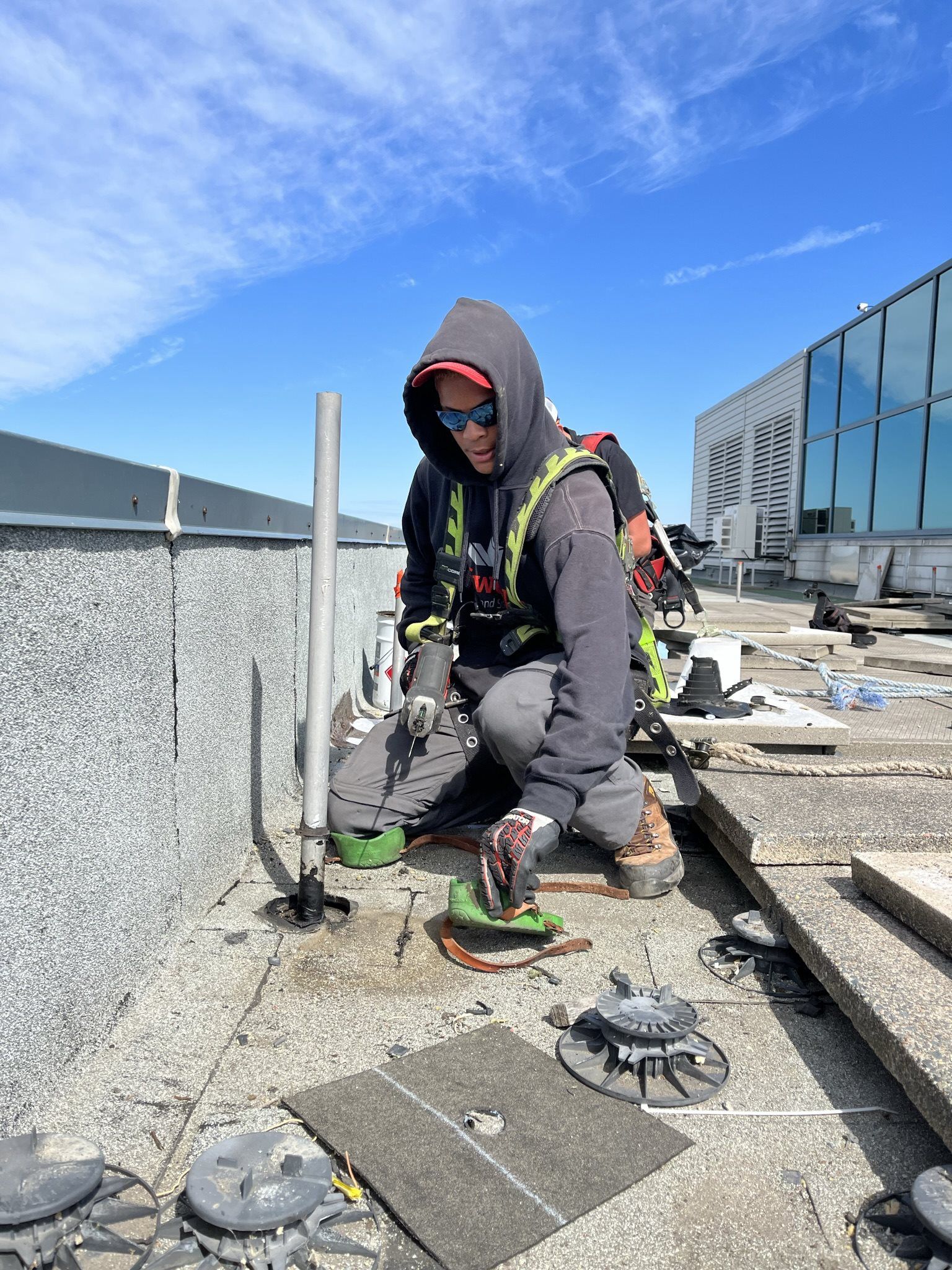 Man repairing flat commercial roof with Soprema Alsans