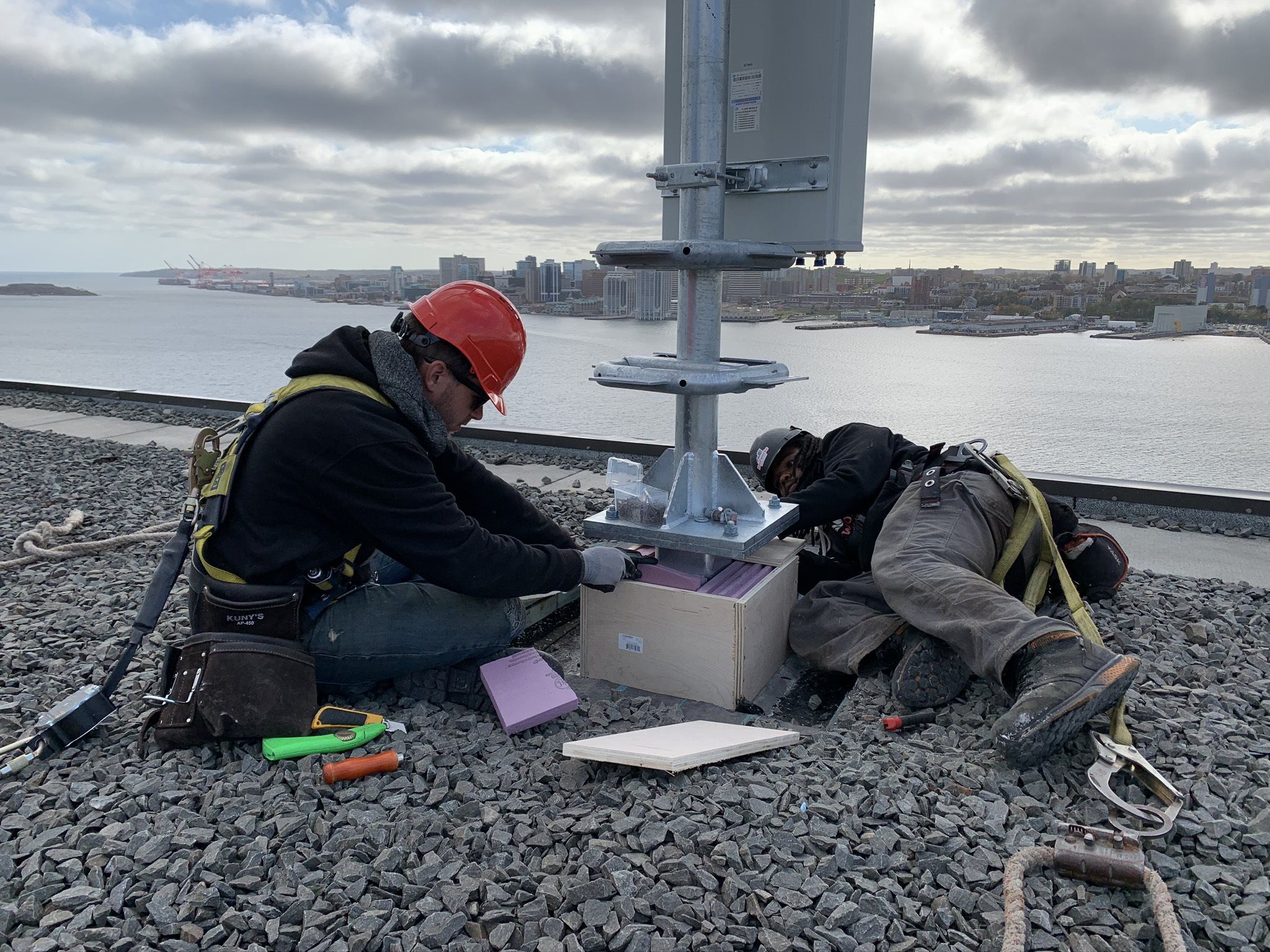 Men repairing satellite on commercial rooftop