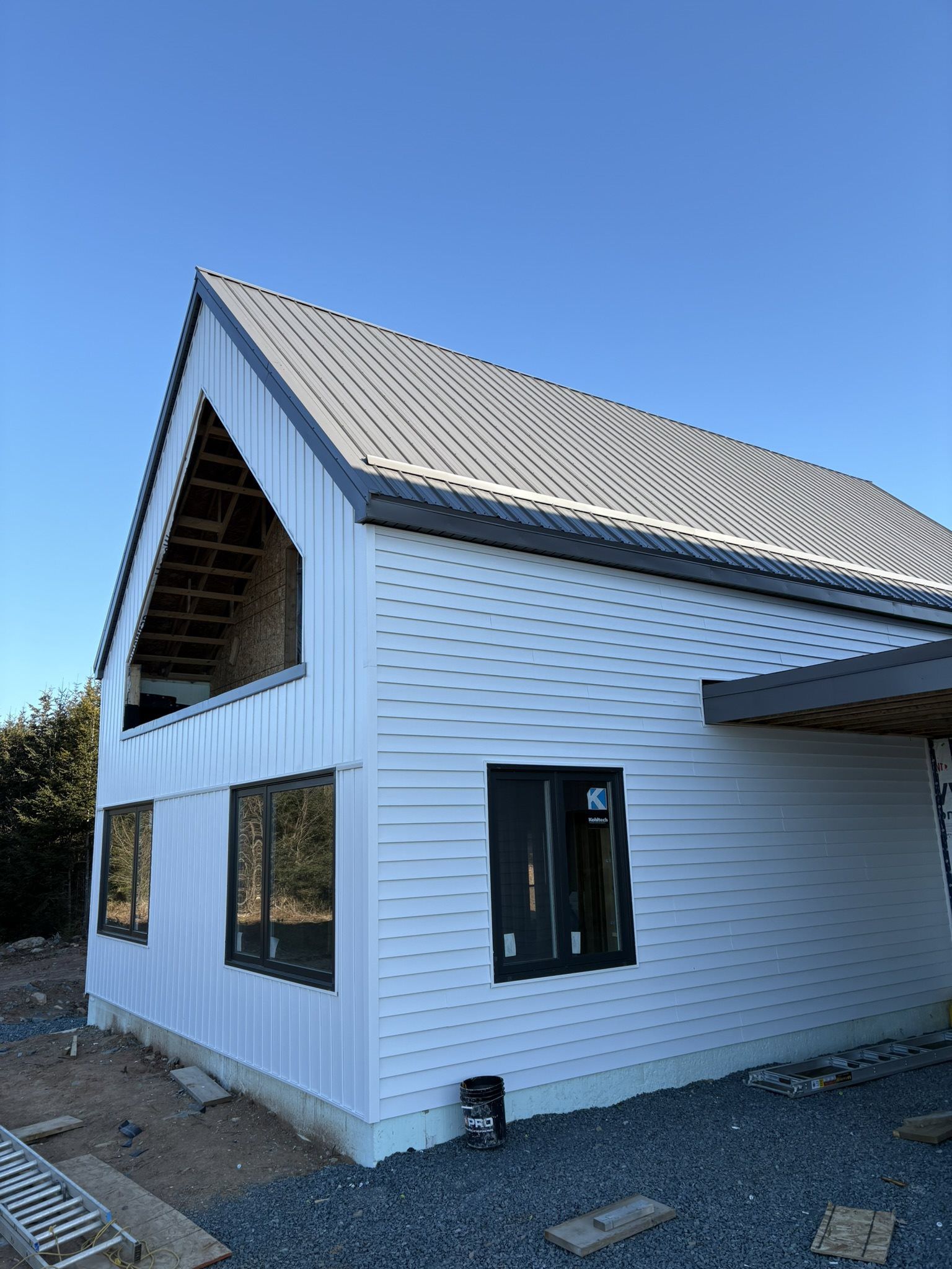 Large white modern farmhouse with grey metal roof
