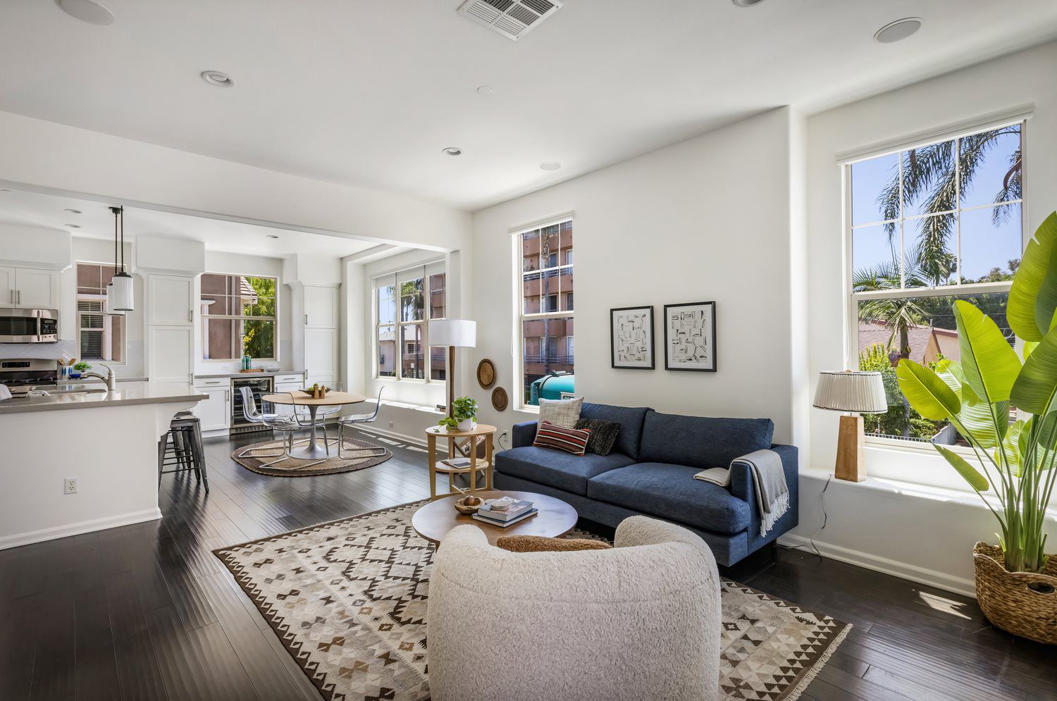 Modern open-concept living room with blue sofa, cozy decor, and natural light.