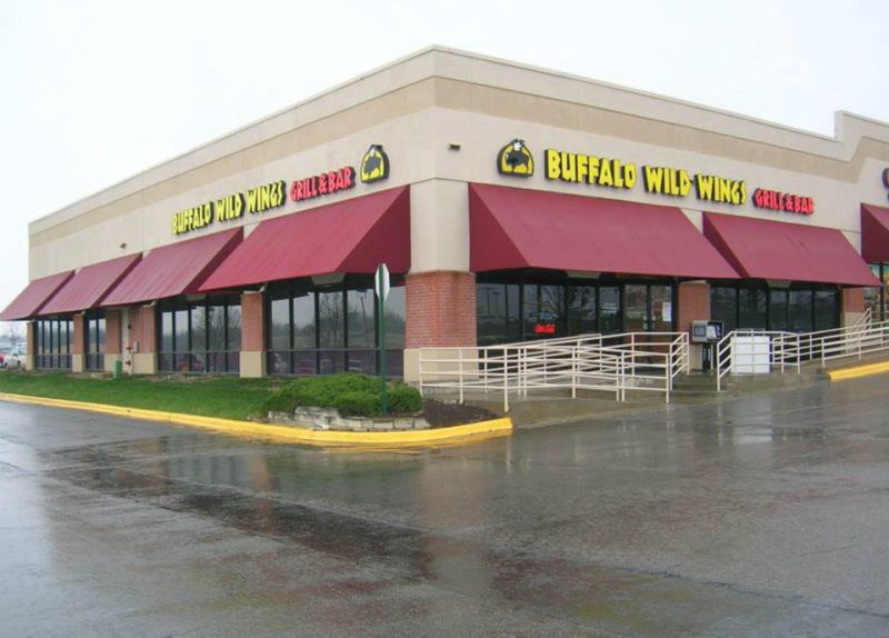 A retractable awning installed on the patio of a modern home. This outdoor shade canopy can be extended and retracted to control sunlight exposure, perfect for residential use. The sleek design complements the home’s exterior, offering flexibility fo