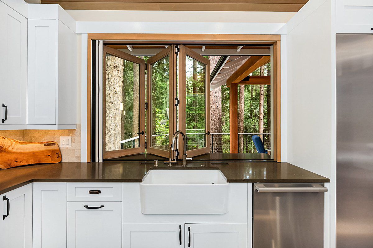 AG Millworks bi-fold kitchen window opening to an outdoor entertaining area