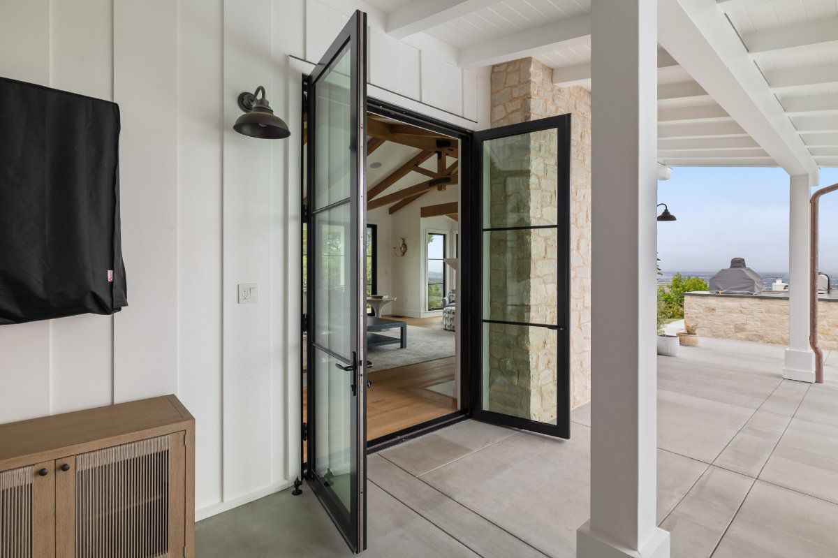 AG Millworks French outswing patio doors opening from a home's interior to a covered patio